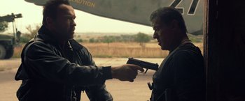 Movie still from “The Expendables 3” (2014), directed by Patrick Hughes – Two men are holding a gun in their hands; Medium shot, Over the shoulder angle