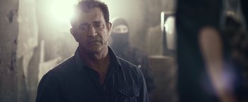 Movie still from “The Expendables 3” (2014), directed by Patrick Hughes – A man in a black shirt is looking to his left; Close Up shot, Over the shoulder angle