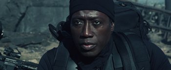 Movie still from “The Expendables 3” (2014), directed by Patrick Hughes – A person wearing a black hat; Close Up shot, Over the shoulder angle