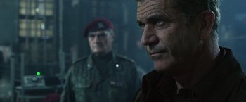 Movie still from “The Expendables 3” (2014), directed by Patrick Hughes – A man in a military uniform standing next to another man in fatigues; Close Up shot, Low angle