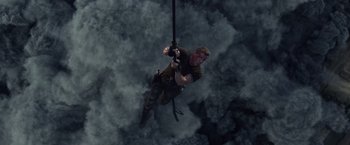 Movie still from “The Expendables 3” (2014), directed by Patrick Hughes – A man hanging from a rope in the middle of the night; Wide shot, Overhead angle