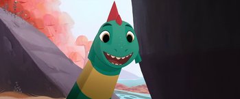 Movie still from “My Father's Dragon” (2022), directed by Nora Twomey – A cartoon of a green and yellow dinosaur with a red mohawk; Medium shot, High angle