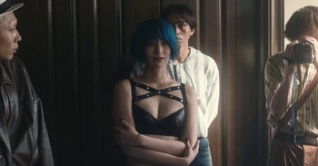 Movie still from “The Forest of Love” (2019), directed by Sion Sono – A man and a woman standing next to each other; Medium shot, Low angle