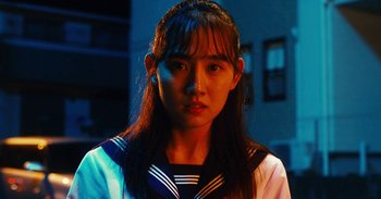 Movie still from “The Forest of Love” (2019), directed by Sion Sono – A young asian woman with long black hair; Close Up shot, Low angle