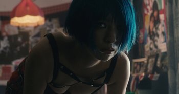 Movie still from “The Forest of Love” (2019), directed by Sion Sono – A woman with blue hair is posing for a picture; Close Up shot, Low angle