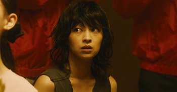 Movie still from “The Forest of Love” (2019), directed by Sion Sono – A young woman with long black hair stares into the distance; Close Up shot, Low angle