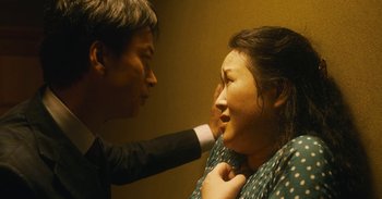 Movie still from “The Forest of Love” (2019), directed by Sion Sono – A man and a woman touching each other's chest; Close Up shot, Low angle