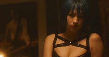 Movie still from “The Forest of Love” (2019), directed by Sion Sono – A woman with blue hair wearing a black bra; Close Up shot, Over the shoulder angle