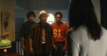 Movie still from “The Forest of Love” (2019), directed by Sion Sono – A group of men standing next to each other in front of a mirror; Medium shot, Low angle