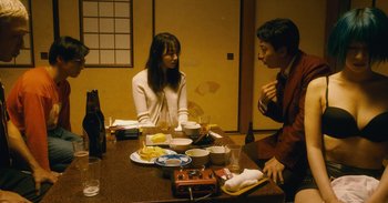 Movie still from “The Forest of Love” (2019), directed by Sion Sono – A man and a woman sitting at a dinner table; Medium shot, High angle