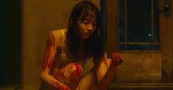 Movie still from “The Forest of Love” (2019), directed by Sion Sono – A woman with blood all over her body; Medium shot, High angle