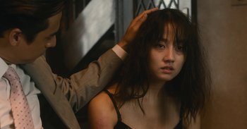 Movie still from “The Forest of Love” (2019), directed by Sion Sono – A woman getting her hair combed by a man; Close Up shot, Over the shoulder angle