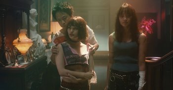 Movie still from “The Forest of Love” (2019), directed by Sion Sono – A group of people standing in a room together; Medium shot, Low angle