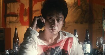 Movie still from “The Forest of Love” (2019), directed by Sion Sono – A man in a white shirt talking on a cell phone; Close Up shot, Low angle