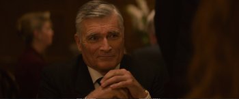 Movie still from “The Glass Castle” (2017), directed by Destin Daniel Cretton – An older man wearing a suit and tie with his hands crossed; Close Up shot, Over the shoulder angle