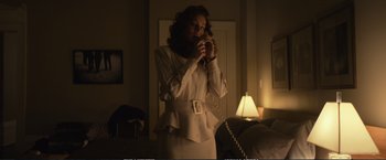 Movie still from “The Glass Castle” (2017), directed by Destin Daniel Cretton – A woman standing in a room holding a phone to her ear; Medium shot, Low angle