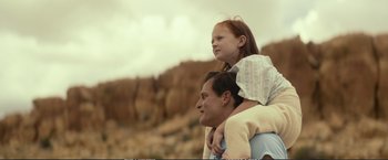 Movie still from “The Glass Castle” (2017), directed by Destin Daniel Cretton – A man and a little girl sitting on the shoulders of another man; Medium shot, Low angle