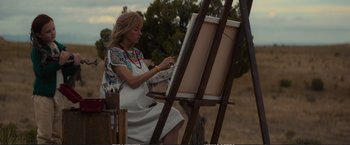 Movie still from “The Glass Castle” (2017), directed by Destin Daniel Cretton – A woman painting a picture on an easel outside; Medium shot, Low angle