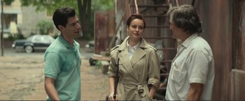 Movie still from “The Glass Castle” (2017), directed by Destin Daniel Cretton – A woman in a trench coat standing next to two other men; Medium shot, Over the shoulder angle