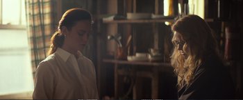 Movie still from “The Glass Castle” (2017), directed by Destin Daniel Cretton – A woman standing next to a shelf in a room; Medium shot, Over the shoulder angle