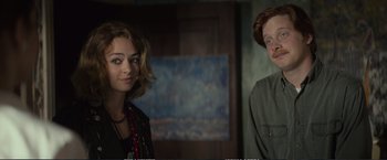 Movie still from “The Glass Castle” (2017), directed by Destin Daniel Cretton – Two people standing next to each other in front of a painting; Close Up shot, Over the shoulder angle