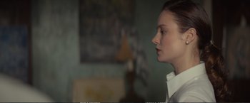 Movie still from “The Glass Castle” (2017), directed by Destin Daniel Cretton – A young woman is standing in front of a painting; Close Up shot, Over the shoulder angle