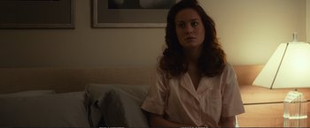 Movie still from “The Glass Castle” (2017), directed by Destin Daniel Cretton – A woman sitting on a couch in a living room; Medium shot, Over the shoulder angle