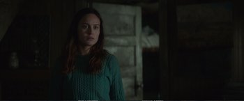 Movie still from “The Glass Castle” (2017), directed by Destin Daniel Cretton – A woman in a green sweater standing next to a door; Medium shot, Over the shoulder angle