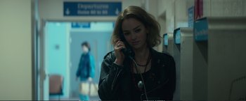 Movie still from “The Glass Castle” (2017), directed by Destin Daniel Cretton – A woman is talking on a phone while standing in a building; Close Up shot, Over the shoulder angle