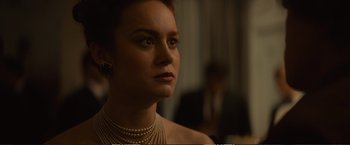 Movie still from “The Glass Castle” (2017), directed by Destin Daniel Cretton – A woman wearing pearls is looking into the distance; Close Up shot, Over the shoulder angle