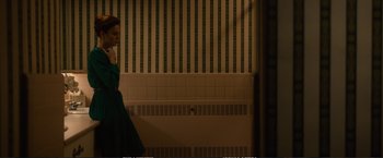 Movie still from “The Glass Castle” (2017), directed by Destin Daniel Cretton – A woman in a green dress in front of a tiled wall; Wide shot, Over the shoulder angle