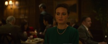 Movie still from “The Glass Castle” (2017), directed by Destin Daniel Cretton – A woman in a green shirt is standing in front of a table; Close Up shot, Over the shoulder angle