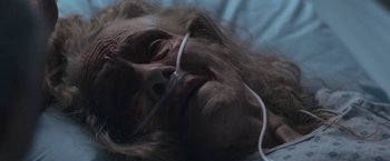 Movie still from “The Good Nurse” (2022), directed by Tobias Lindholm – An old woman laying in a bed with her eyes closed; Close Up shot, High angle