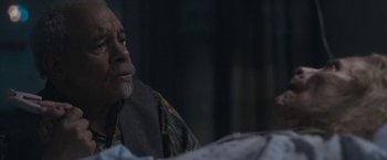 Movie still from “The Good Nurse” (2022), directed by Tobias Lindholm – An older man sitting in front of a window; Close Up shot, Over the shoulder angle