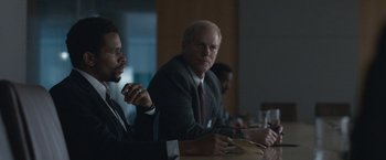 Movie still from “The Good Nurse” (2022), directed by Tobias Lindholm – A man in a suit and tie sitting at a table; Medium shot, Over the shoulder angle