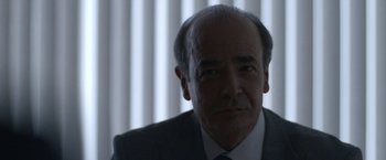 Movie still from “The Good Nurse” (2022), directed by Tobias Lindholm – A person wearing a suit and tie; Close Up shot, Over the shoulder angle