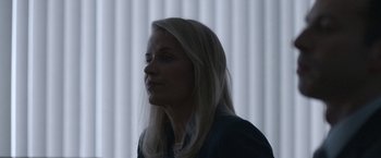 Movie still from “The Good Nurse” (2022), directed by Tobias Lindholm – A woman with long blonde hair is standing in front of a window; Close Up shot, Over the shoulder angle