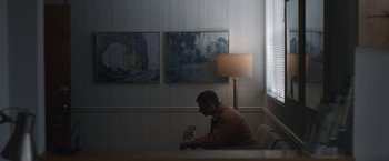 Movie still from “The Good Nurse” (2022), directed by Tobias Lindholm – A man sitting at a table in front of a window; Wide shot, Low angle