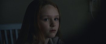 Movie still from “The Good Nurse” (2022), directed by Tobias Lindholm – A young girl with long red hair stares into the camera; Close Up shot, Over the shoulder angle
