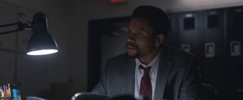 Movie still from “The Good Nurse” (2022), directed by Tobias Lindholm – A man wearing a suit and tie sitting at a table; Close Up shot, Low angle