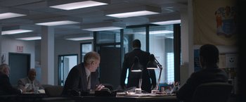 Movie still from “The Good Nurse” (2022), directed by Tobias Lindholm – A man sitting at a desk in front of a window; Wide shot, Over the shoulder angle