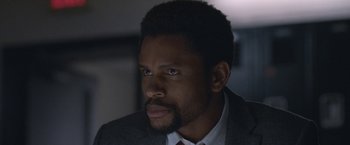 Movie still from “The Good Nurse” (2022), directed by Tobias Lindholm – A person wearing a suit and tie; Close Up shot, Over the shoulder angle