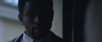 Movie still from “The Good Nurse” (2022), directed by Tobias Lindholm – A person wearing a suit and tie; Close Up shot, Over the shoulder angle