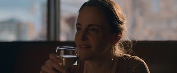 Movie still from “The Good Nurse” (2022), directed by Tobias Lindholm – A woman holding a glass of wine in her right hand; Close Up shot, Over the shoulder angle