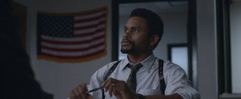 Movie still from “The Good Nurse” (2022), directed by Tobias Lindholm – A man in a white dress shirt and tie holding a pair of scissors; Medium shot, Low angle