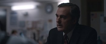 Movie still from “The Good Nurse” (2022), directed by Tobias Lindholm – A person wearing a suit and tie; Close Up shot, Over the shoulder angle