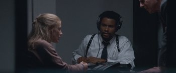 Movie still from “The Good Nurse” (2022), directed by Tobias Lindholm – A man and a woman are listening to headphones; Medium shot, Over the shoulder angle