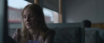 Movie still from “The Good Nurse” (2022), directed by Tobias Lindholm – A woman sitting on a couch holding a drink; Close Up shot, Over the shoulder angle