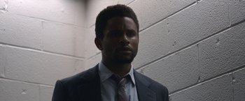 Movie still from “The Good Nurse” (2022), directed by Tobias Lindholm – A man wearing a suit and tie in a room; Close Up shot, Low angle