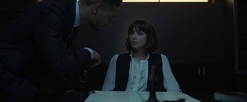 Movie still from “The Gray Man” (2022), directed by Joe Russo – A woman sitting at a table in front of a man; Medium shot, Over the shoulder angle